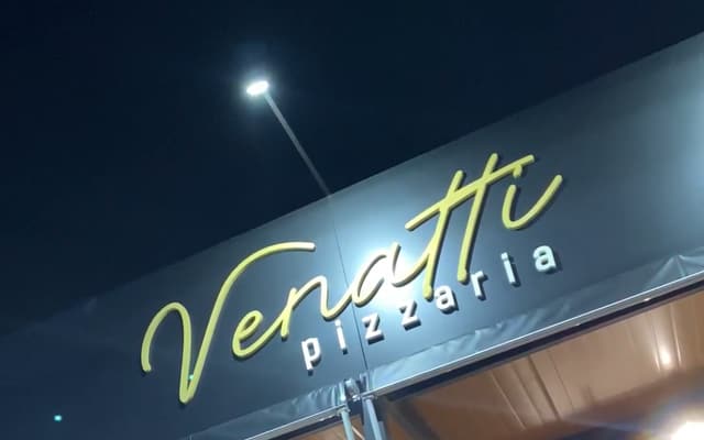 Fachada da Venatti à noite com o letreiro aceso